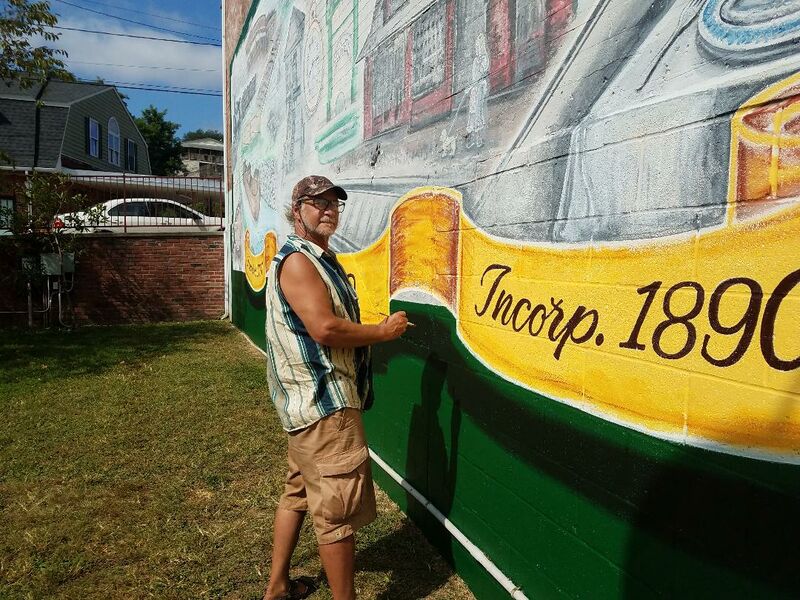 File:Philip Aldinger renews the Square Corner Park Mural, 2020.jpg