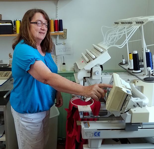 File:Brunswick Hardware Apparel Dept, Abbie Ricketts doing embroidery, July 7, 2017 in Brunswick. Photo Jerry Knight.jpg