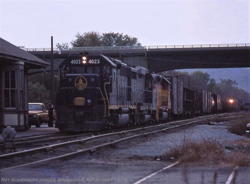 File:It's an early evening in August 1975 as two eastbound trains prepare to depart from Brunswick, MD.jpg