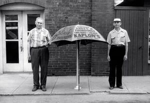 Amos Kaplon and Johnnie Grim with an advertising sign.jpg